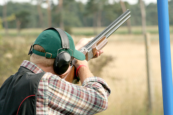 Man aiming a gun at a clay target