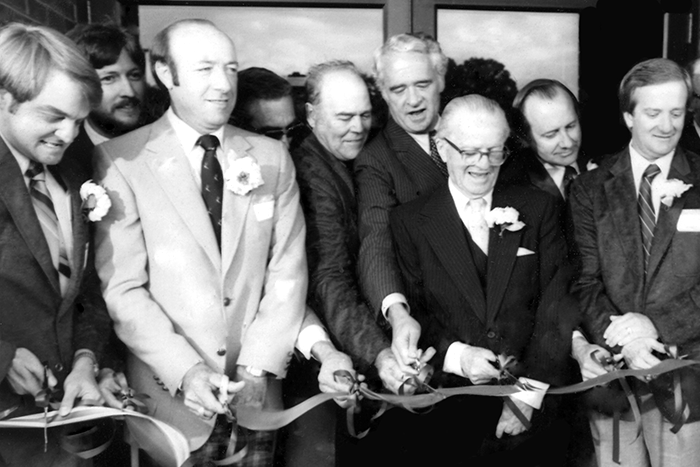 group of people cutting a ribbon