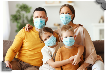 Family of four sitting on a couch wearing masks