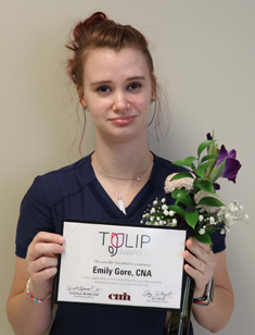 Emily Gore, CNA holding TULIP Award certificate and flowers