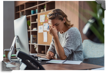 Woman suffering from migraine at desk